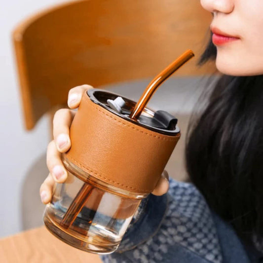 Woman drinking from glass tumbler with straw in Pakistan