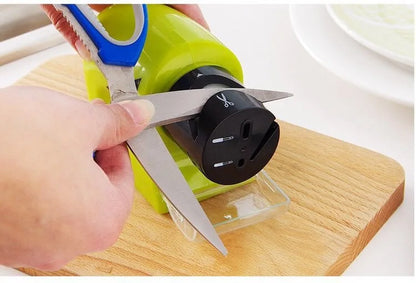 Electric knife grinder sharpening scissors on wooden cutting board in Pakistan